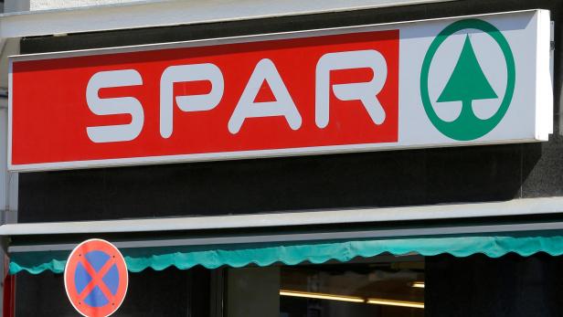 FILE PHOTO: The logo of Austrian supermarket chain Spar is seen behind a traffic sign at a shop in Vienna