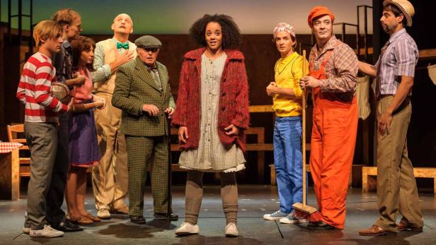 Eine Gruppe von Schauspielern steht auf einer Bühne in Kostümen.