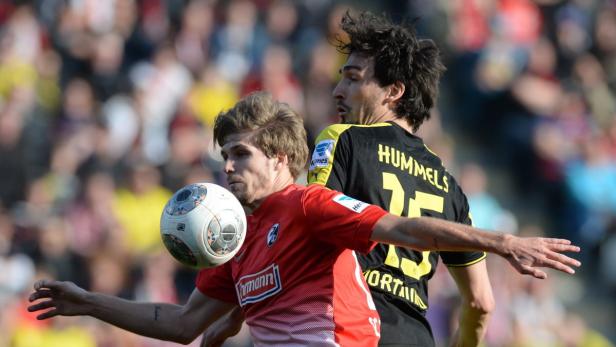 Zwei Fußballspieler kämpfen um den Ball während eines Spiels.