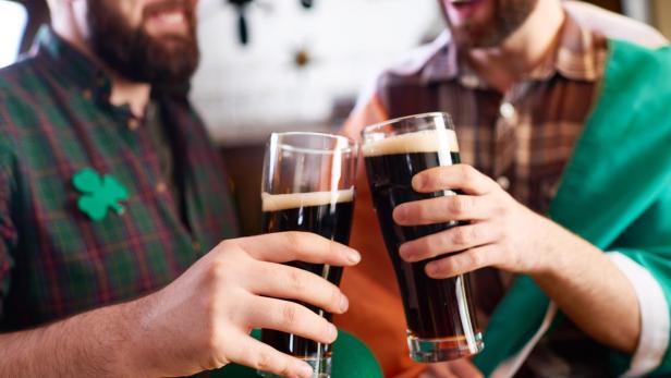 Zwei Männer stoßen mit irischem Stout auf den St. Patrick's Day an.