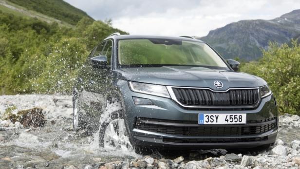 Ein grauer Škoda Kodiaq fährt durch einen steinigen Fluss.