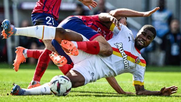 Ein Fußballspieler wird während eines Spiels zu Fall gebracht.