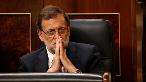 Mariano Rajoy sitzt mit gefalteten Händen da und blickt nachdenklich.