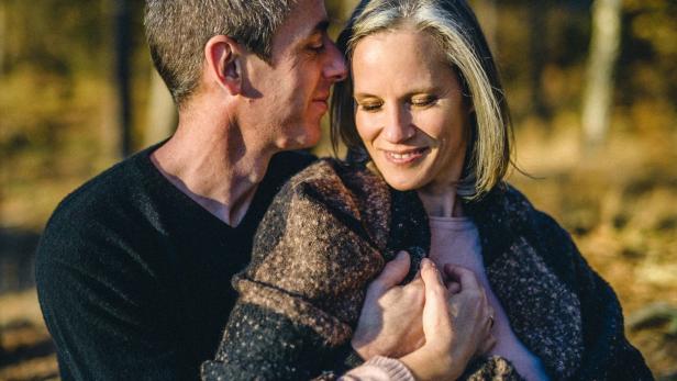 Ein Paar umarmt sich liebevoll im Freien.