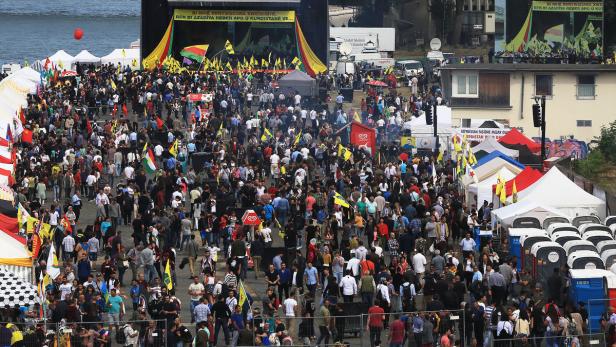 Eine große Menschenmenge versammelt sich zu einer Kundgebung mit kurdischen Flaggen.