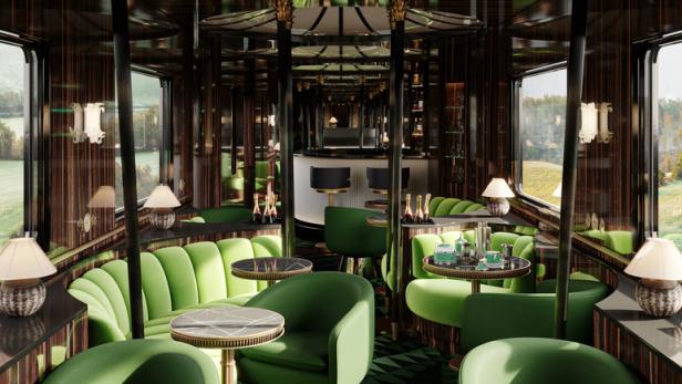 Der luxuriöse Salonwagen eines Zuges mit grünen Sitzen und einer Bar im Hintergrund.