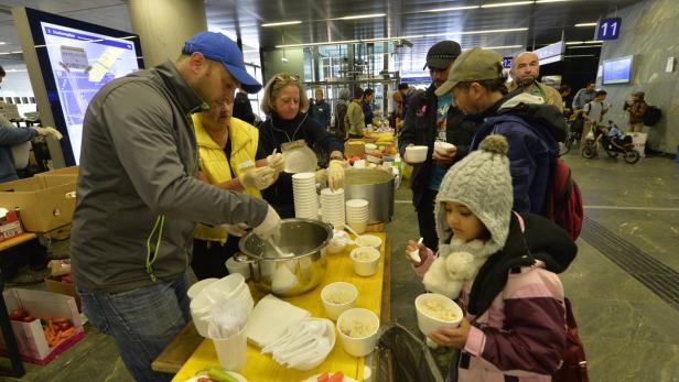 Freiwillige beim Essenausteilen am Wiener Hauptbahnhof.