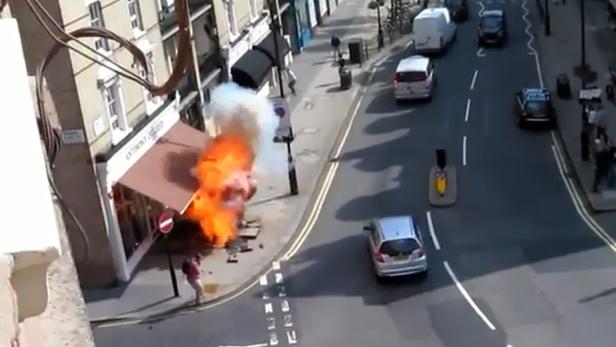 Eine Explosion vor einem Gebäude in einer belebten Straße.