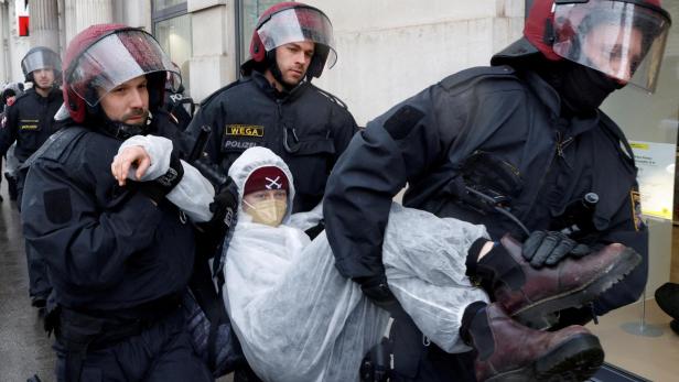Austrian police officers remove protester during demonstration against international gas conference in Vienna