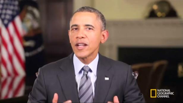 Barack Obama spricht vor einem Hintergrund mit der US-amerikanischen Flagge.