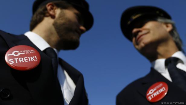 Zwei Piloten mit Anstecknadeln der „Vereinigung Cockpit“ mit der Aufschrift „Streik!“.