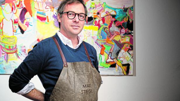 Max Stiegl steht vor einem seiner farbenfrohen Gemälde.