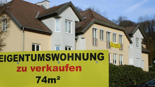Ein Schild vor dem Haus mit dem Schriftzug "Eigentumswohnung zu verkaufen"