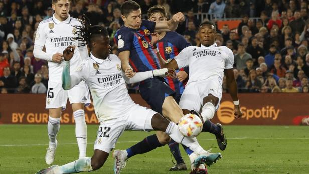 Während eines Fußballspiels kämpfen Spieler von Real Madrid und Barcelona um den Ball.