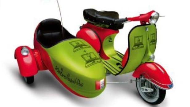 Ein rot-grüner Motorroller mit Beiwagen, verziert mit Laptop-Symbolen und dem Schriftzug „20M Breitband Duo“.