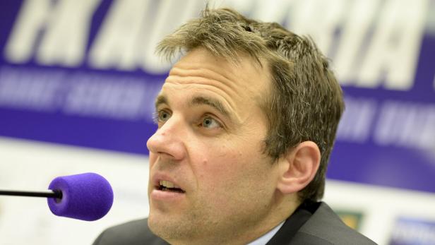 Ein Mann spricht in ein Mikrofon mit lila Windschutz.