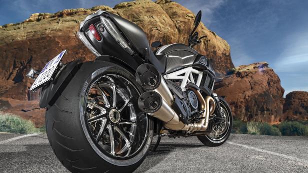 Eine Ducati Diavel vor einer Felsformation in einer Wüstenlandschaft.