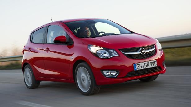 Ein roter Opel fährt auf einer Landstraße.