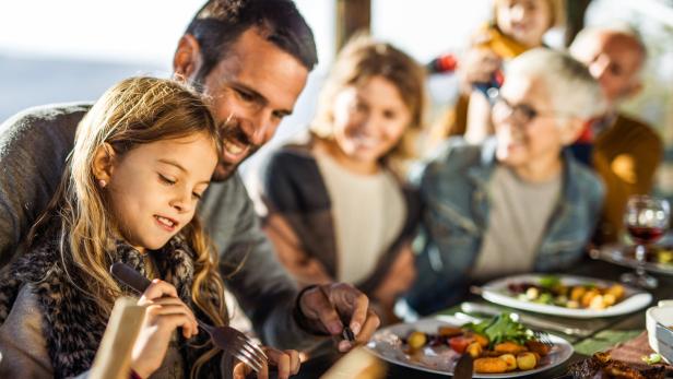 Eine Familie genießt gemeinsam ein festliches Essen am Tisch.