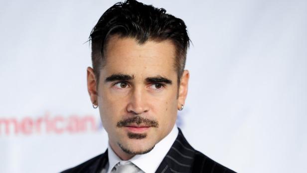 Porträt von Colin Farrell mit Ohrringen und einem dunklen Anzug.