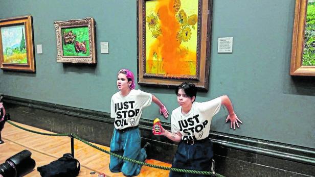 FILE PHOTO: Activists of "Just Stop Oil" glue their hands to the wall after throwing soup at a van Gogh's painting "Sunflowers" at the National Gallery in London