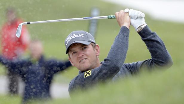 Ein Golfspieler schlägt einen Ball aus einem Bunker.