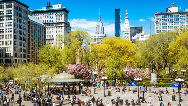 Der Union Square Park in New York City mit Menschen und Blick auf die Skyline.