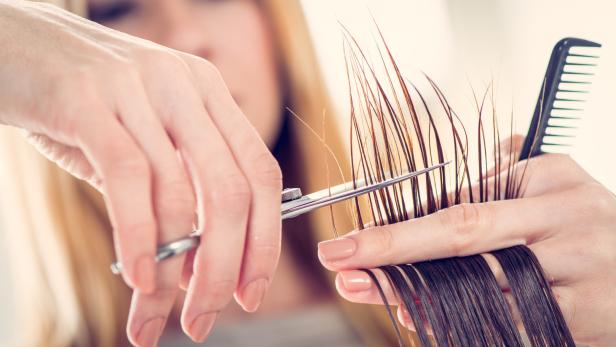 Eine Friseurin schneidet einer Kundin die Haare.