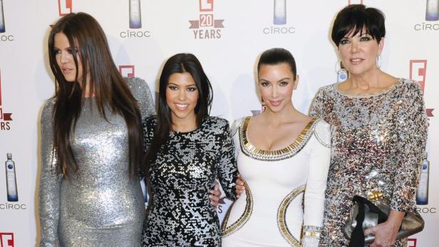Die Kardashian-Schwestern Khloé, Kourtney, Kim und ihre Mutter Kris Jenner posieren auf einem roten Teppich.