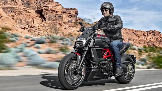 Ein Mann fährt mit einer Ducati Diavel durch eine Wüstenlandschaft.