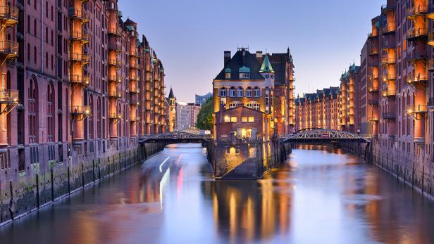 Die Speicherstadt in Hamburg mit ihren beleuchteten Backsteingebäuden und Wasserstraßen.