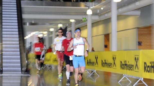 Mehrere Läufer nehmen an einem Rennen in einem Innenraum teil.