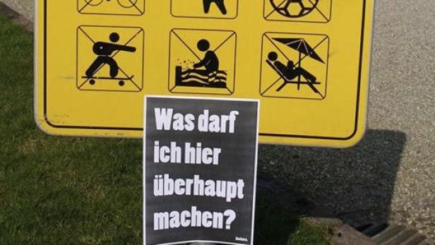 Ein gelbes Schild mit Piktogrammen verschiedener Freizeitaktivitäten und ein Plakat mit der Aufschrift „Was darf ich hier überhaupt machen?“.