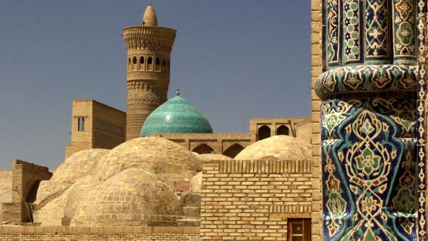 Ein Blick auf historische Gebäude mit einer türkisfarbenen Kuppel und einem verzierten Turm.