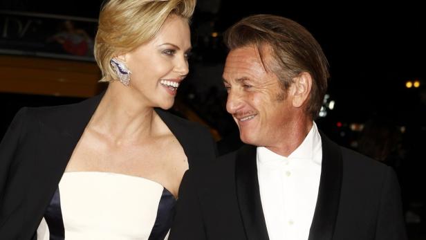 Charize Theron and actor Sean Penn arrive at the M Charlize Theron und Sean Penn lächeln sich auf einer Veranstaltung an.