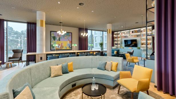 Ein modern gestalteter Aufenthaltsraum mit Sitzgelegenheiten und Bücherregalen.