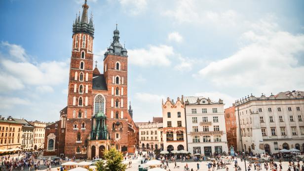 Die gotischen Türme der Marienkirche überragen den Krakauer Hauptmarkt. Ein Trompeter bläst oben stündlich ein Signal in alle Himmelsrichtungen