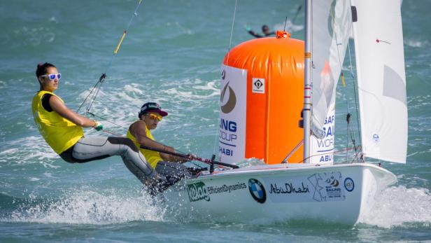 Zwei Seglerinnen steuern ein Segelboot während eines Wettbewerbs in Abu Dhabi.