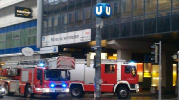 Zwei rote Feuerwehrautos stehen vor einem Gebäude mit einem U-Bahn-Symbol.