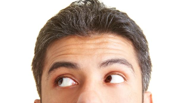 Das Gesicht eines Mannes mit graumeliertem Haar, der nach oben und zur Seite schaut.