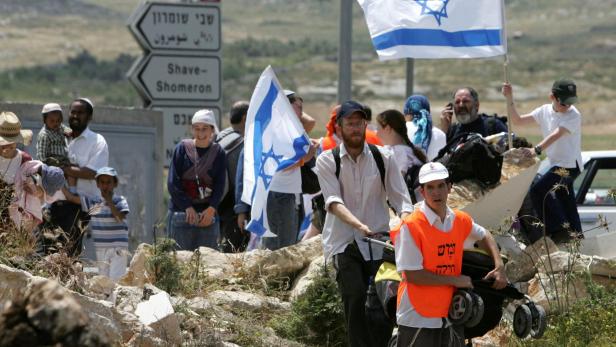 FILE PHOTO: Israeli activists walk towards the former Jewish settlement of Homesh