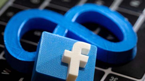 FILE PHOTO: A 3D printed Facebook's new rebrand logo Meta and Facebook logo are placed on laptop keyboard in this illustration