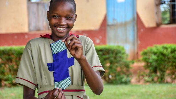 Zarinah (15) zeigt stolz eine der wiederverwendbaren Binden, die sie selbst genäht hat