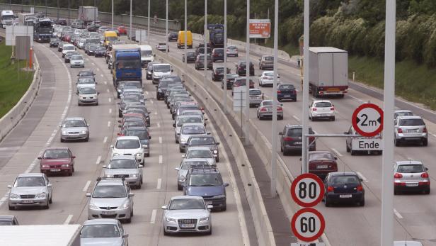 Stau auf einer mehrspurigen Autobahn mit zahlreichen Autos und LKW.