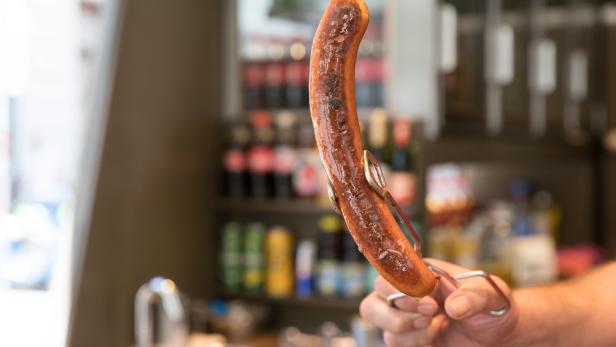 Gebratene Wurst bei einem Wiener Würstelstand.
