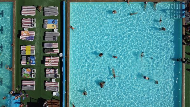 People rest in a swimming pool during a summer day in Izhevsk