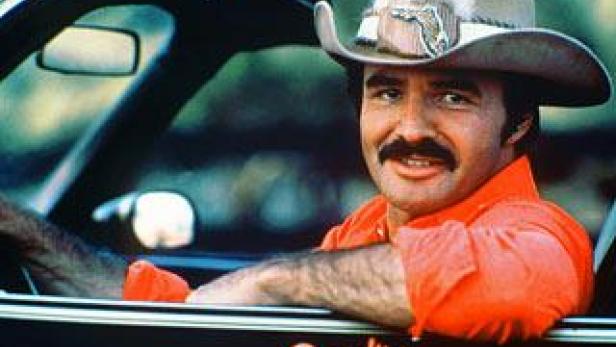 Burt Reynolds sitzt in einem Auto mit der Aufschrift „Bandit“.