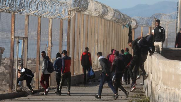 Migranten versuchen über den Grenzwall in Ceuta nach Spanien zu gelangen