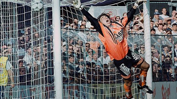 Ein Torwart springt, um einen Fußball während eines Spiels zu halten.
