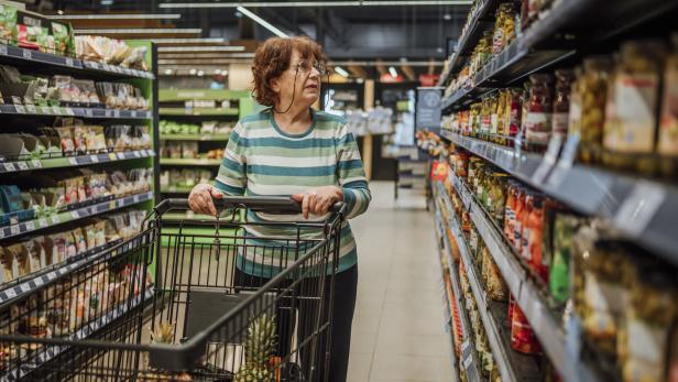 Eine ältere Frau schaut sich in einem Supermarkt um